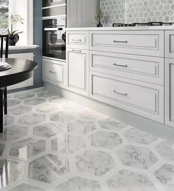 Elegant kitchen with white cabinetry and intricate patterned hexagonal floor tiles